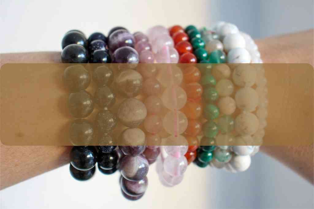 A crystal bracelet stack of 10 bracelets, including dream amethyst, moonstone, malachite and carnelian. The caption is 'bracelets, every colour for every day, shop now'