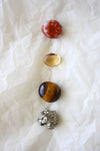This image shows the four tumble stones of the Leo Zodiac Crystal Kit, which are (from top to bottom): Carnelian, Citrine, Tigers Eye, Pyrite
