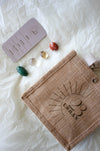 The 23 Urban Aries Zodiac Crystal Kit as a flat lay, showing the Zodiac card that comes with the kit, the four tumble stones for Aries (Carnelian, Citrine, Clear Quartz and Aventurine) and the 23 Urban branded jute gift bag.  