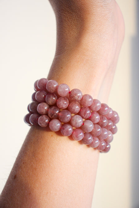 A stack of four pale Pink Amethyst bracelets against a white background 