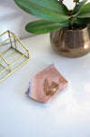 A pink ocean jasper slab sits on a white table