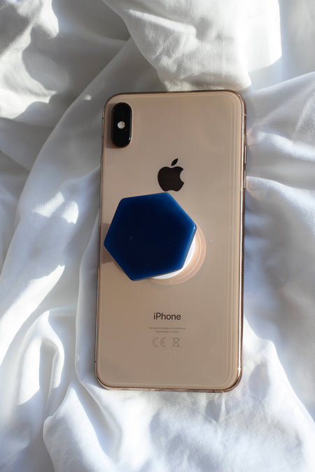 Blue Agate Crystal Phone Grip on the back of a rose gold iPhone on a white background
