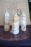 Three cream and orange banded Orange Calcite towers sit in front of a 23 Urban branded jute bag