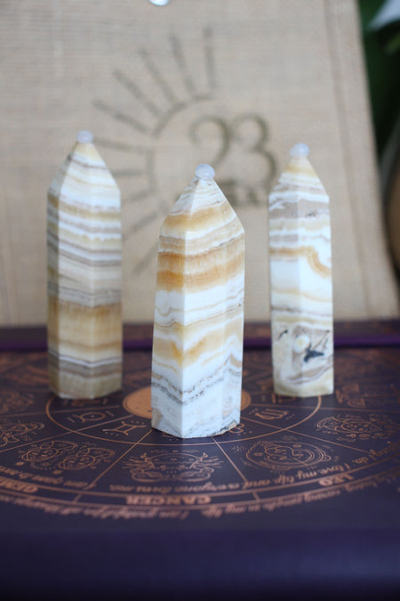 Three cream and orange banded Orange Calcite towers sit in front of a 23 Urban branded jute bag