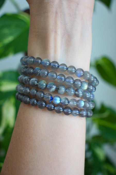 A stack of 5 Labradorite bracelets with blue flash are on a wrist