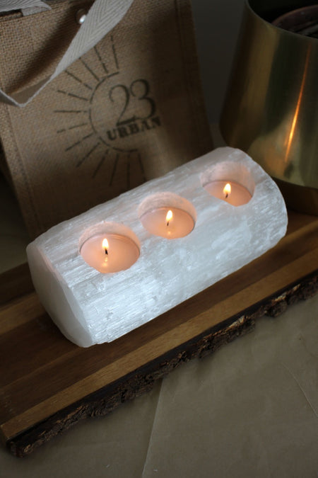 A huge white selenite log with three tea lights embedded into it 