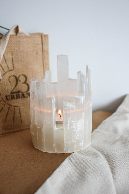 Beautiful Selenite Icicle Tealight Holder with a lit candle inside, showing it's wintery beauty. Dubai Crystals. 23 Urban.