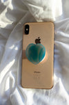 Blue Agate Heart Crystal Phone Grip on the back of a rose gold iPhone on a white background