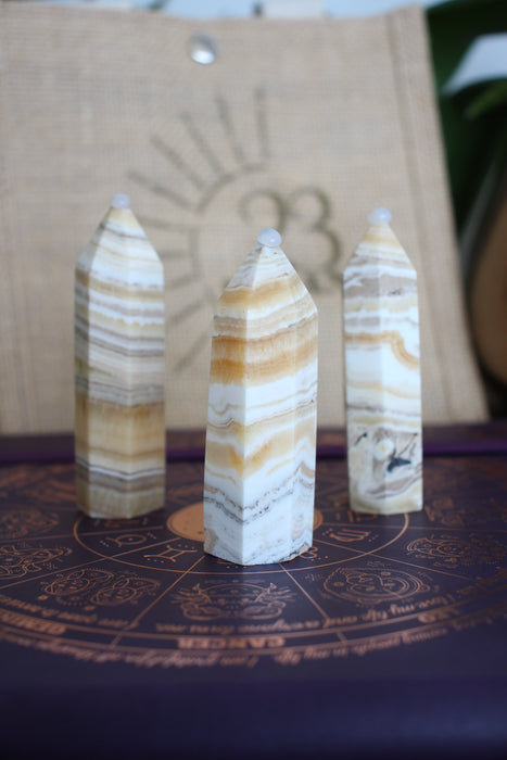 Three cream and orange banded Orange Calcite towers sit in front of a 23 Urban branded jute bag