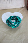 A stack of 5 Malachite bracelets in a Selenite bowl