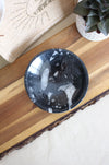 A beautiful glossy black marble bowl containing he fossils of Ammonites and Orthoceras